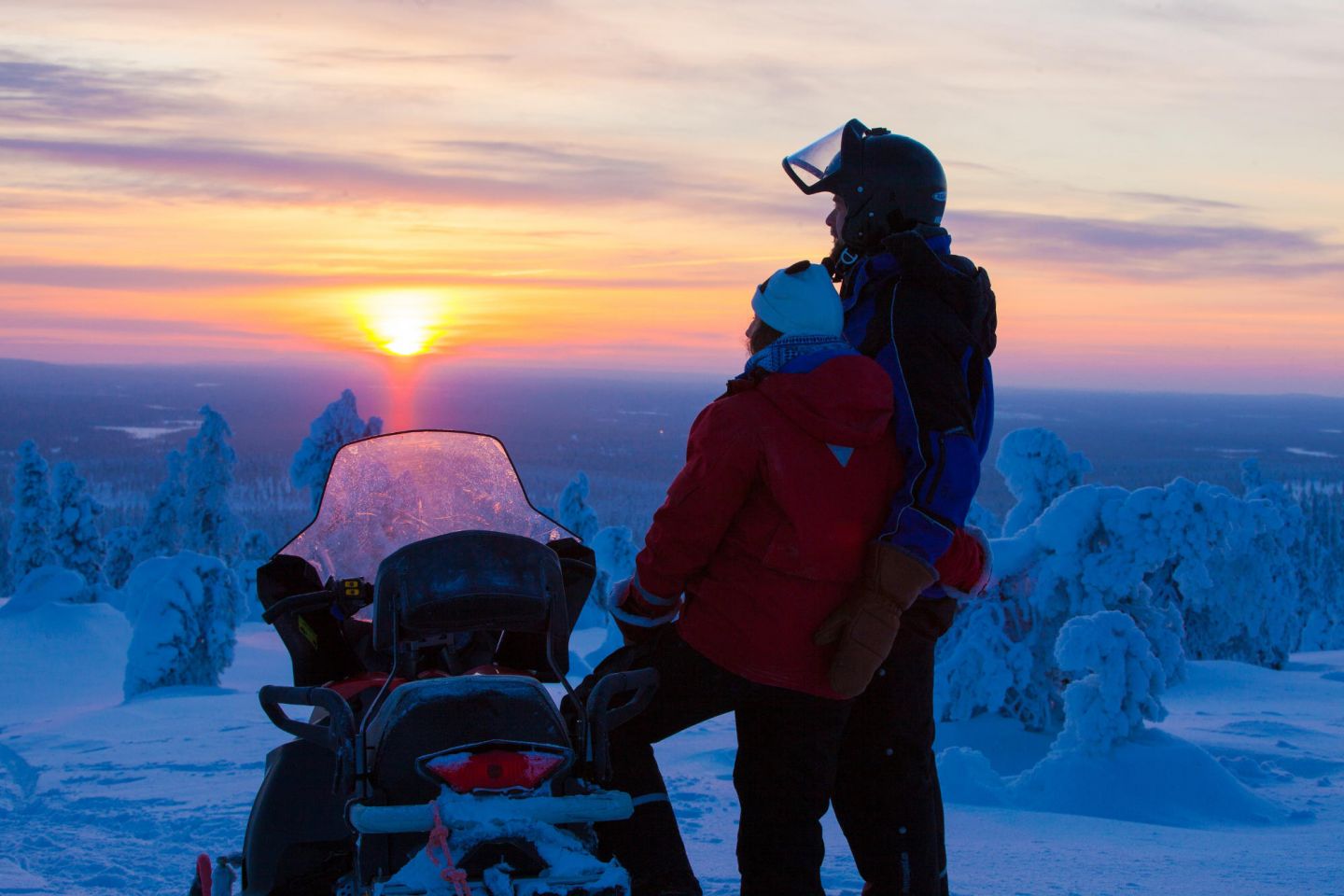 snowmobile ride at sunset during winter in Lapland