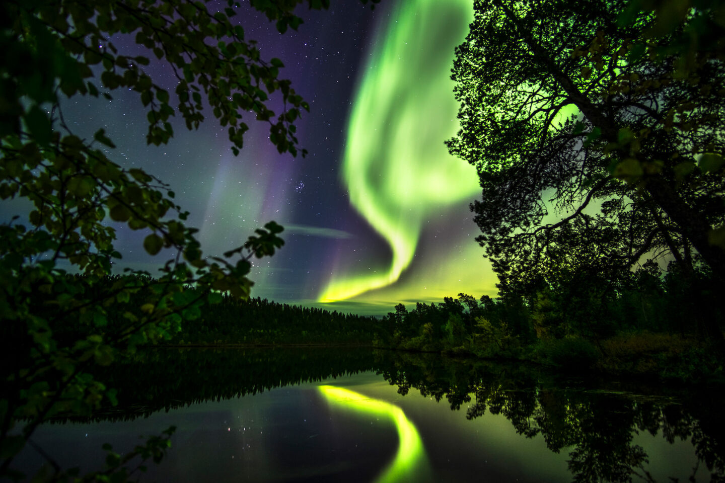 Northern Lights reflecting in autumn waters in Finnish Lapland