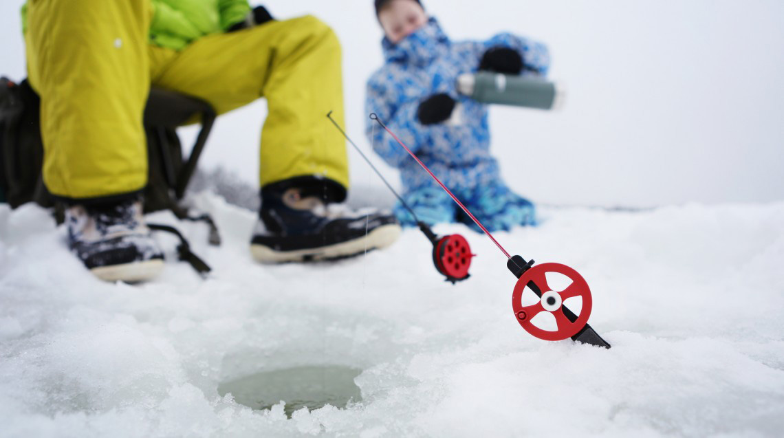 Ice-fishing on a frozen river in spring in Lapland