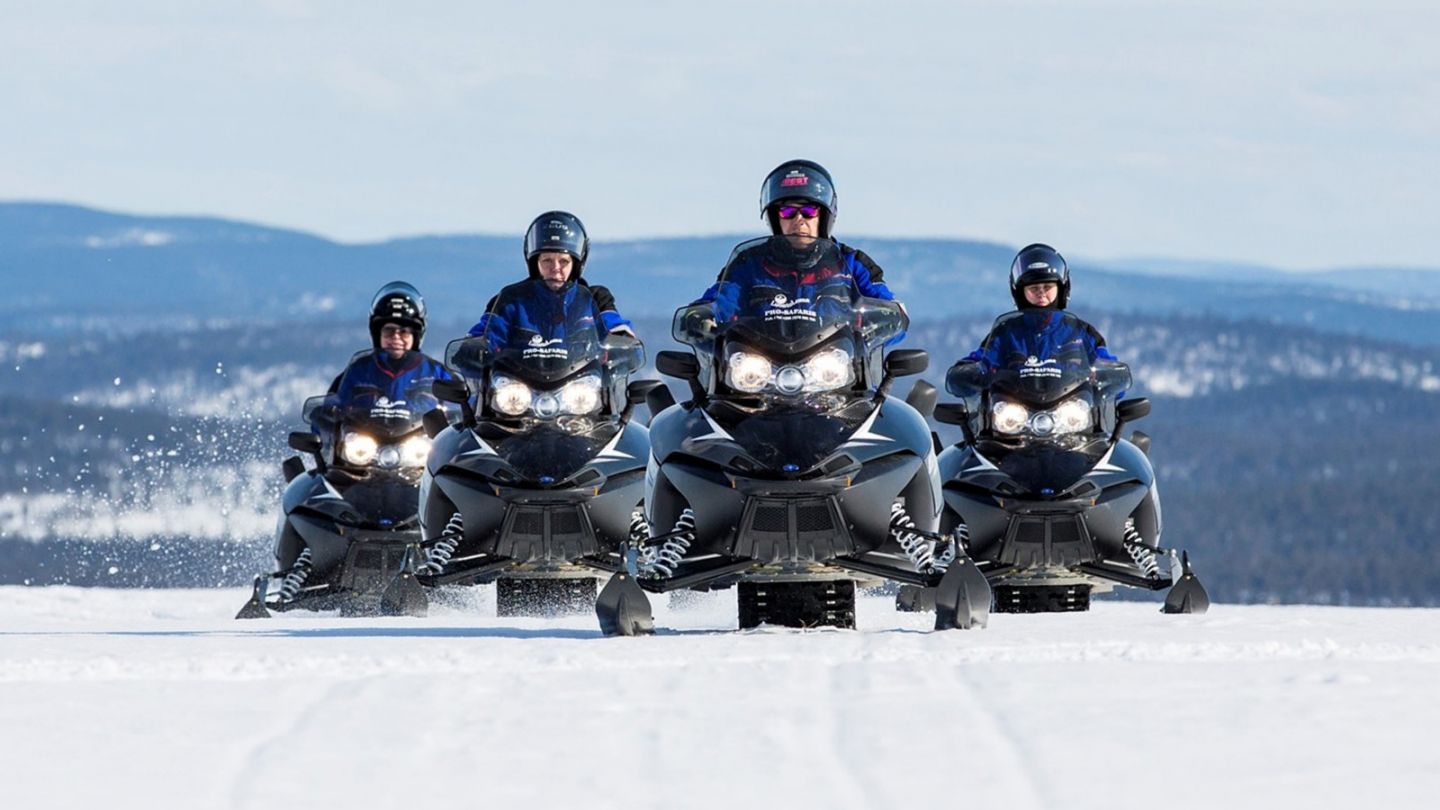 Snowmobiling across frozen Lake Inari in northern Finland in spring