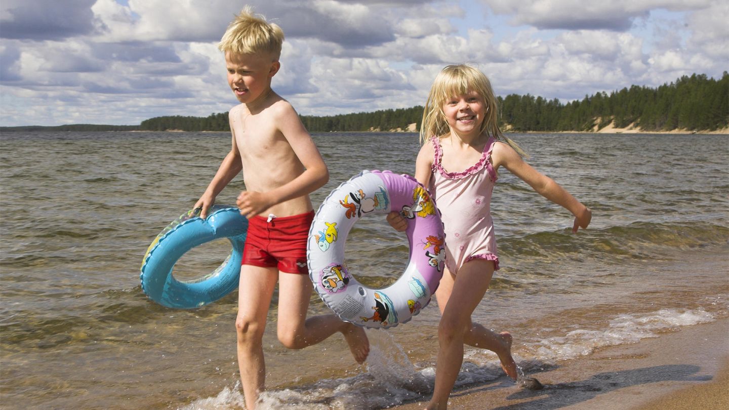 Children playing at the beach under the Lapland summer sun