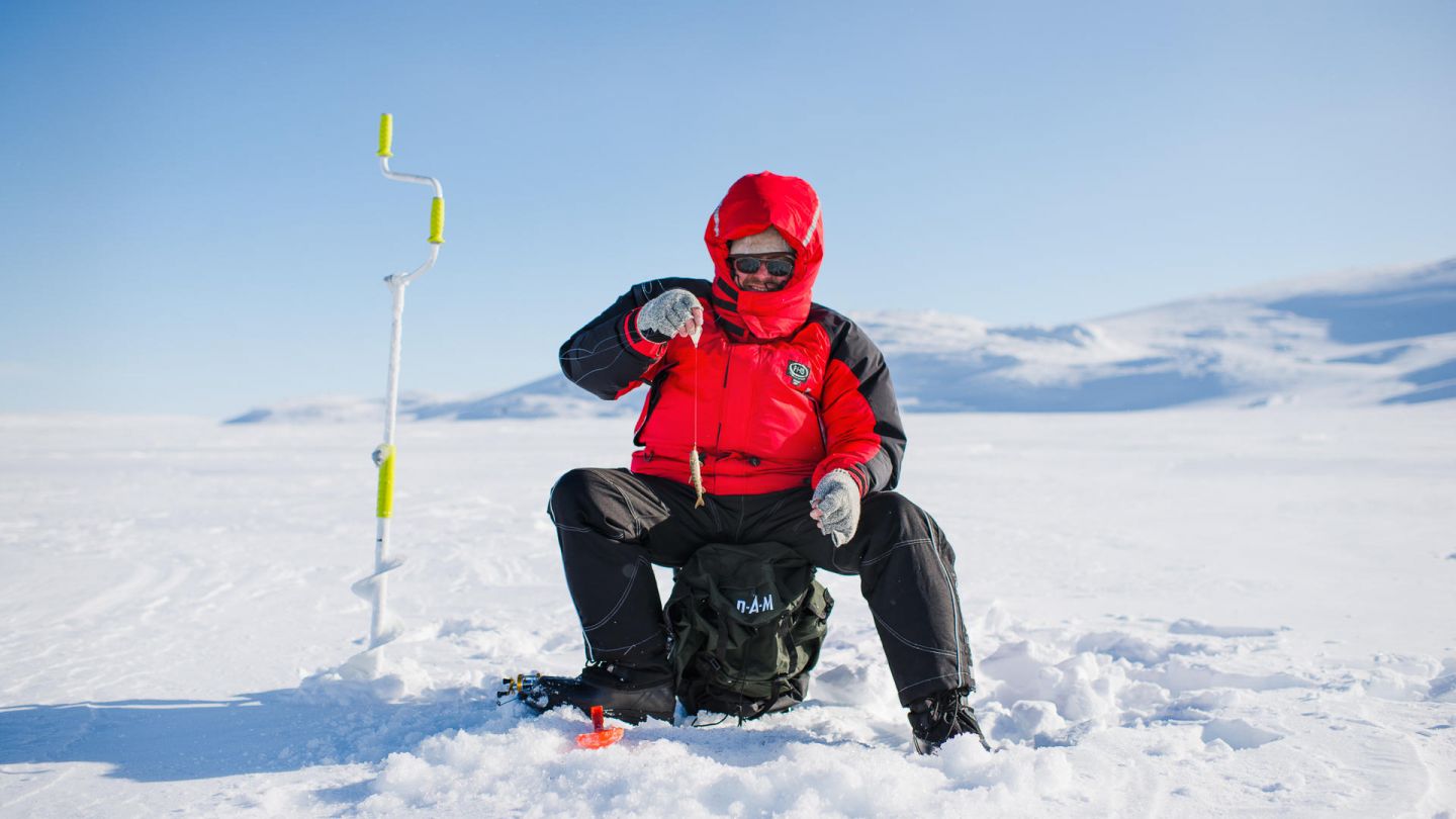 Ice fishing under the Lapland winter sun