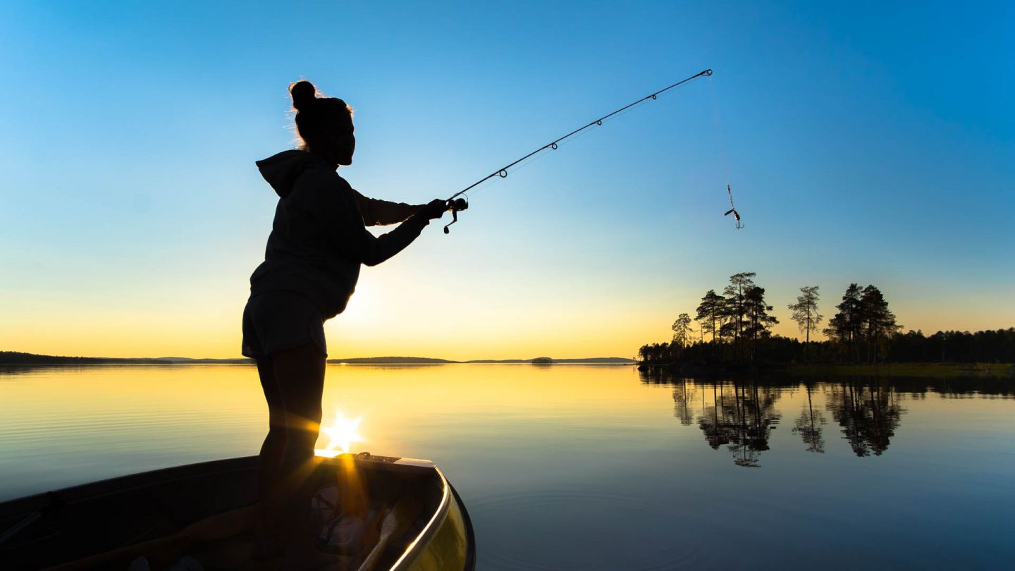 Fisher on lake during sunset