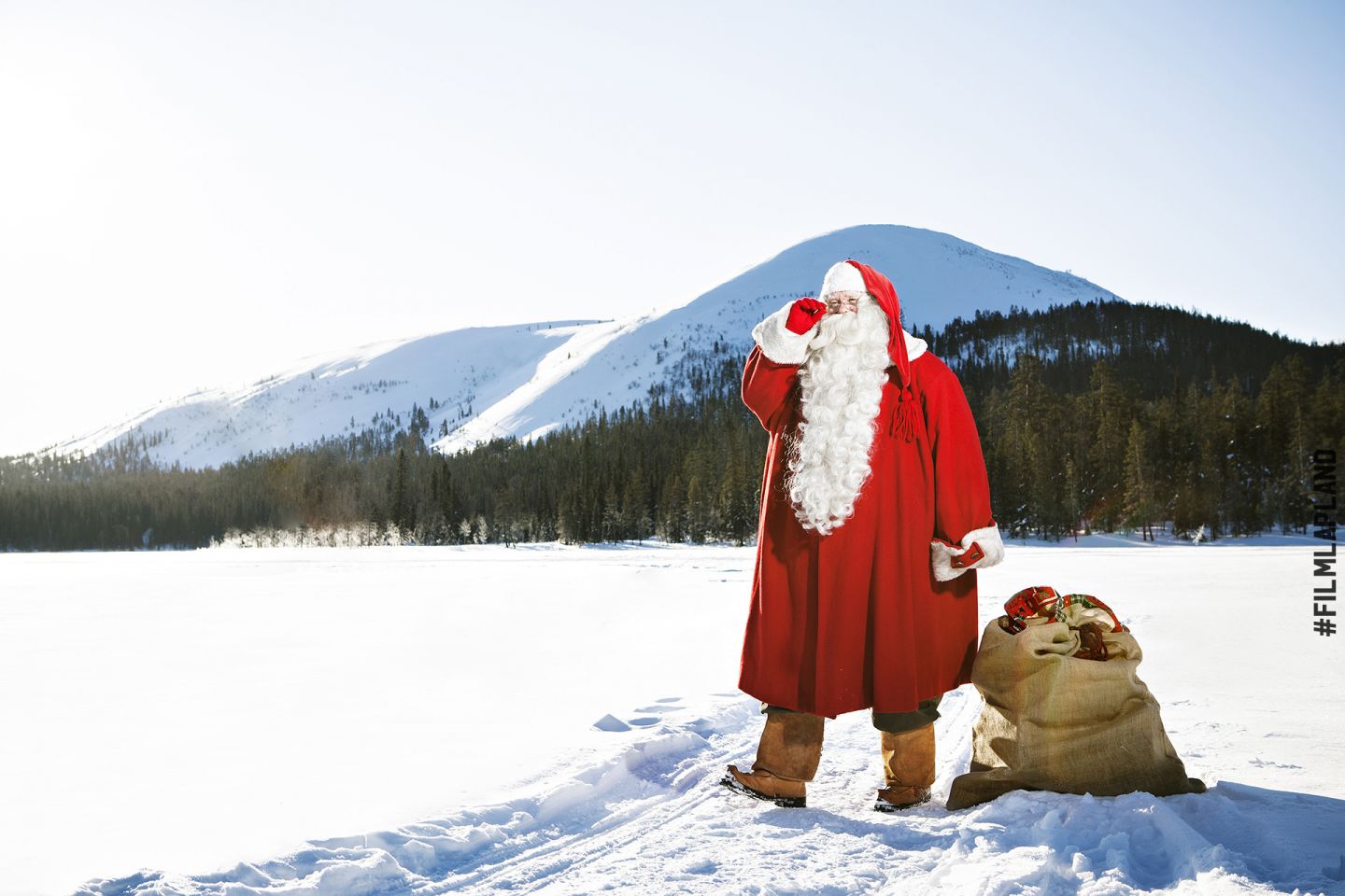 Santa Claus stands atop a frozen lake in Lapland