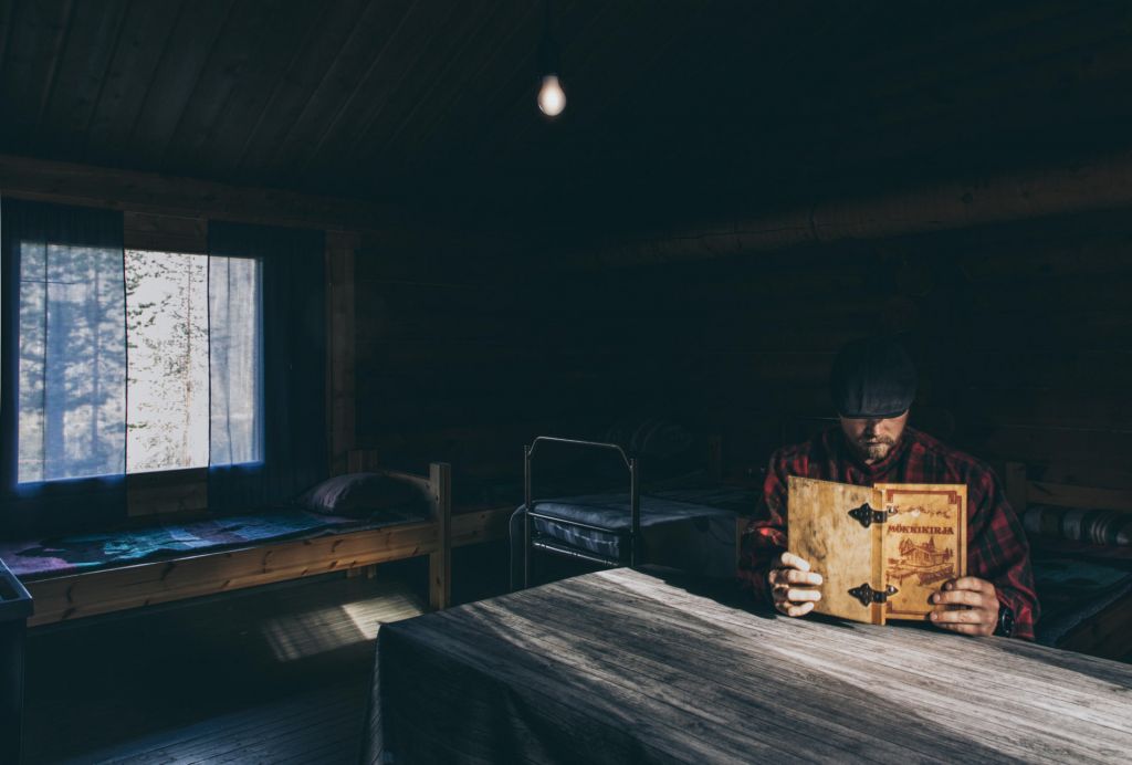 reading a book inside a cabin in Finnish Lapland