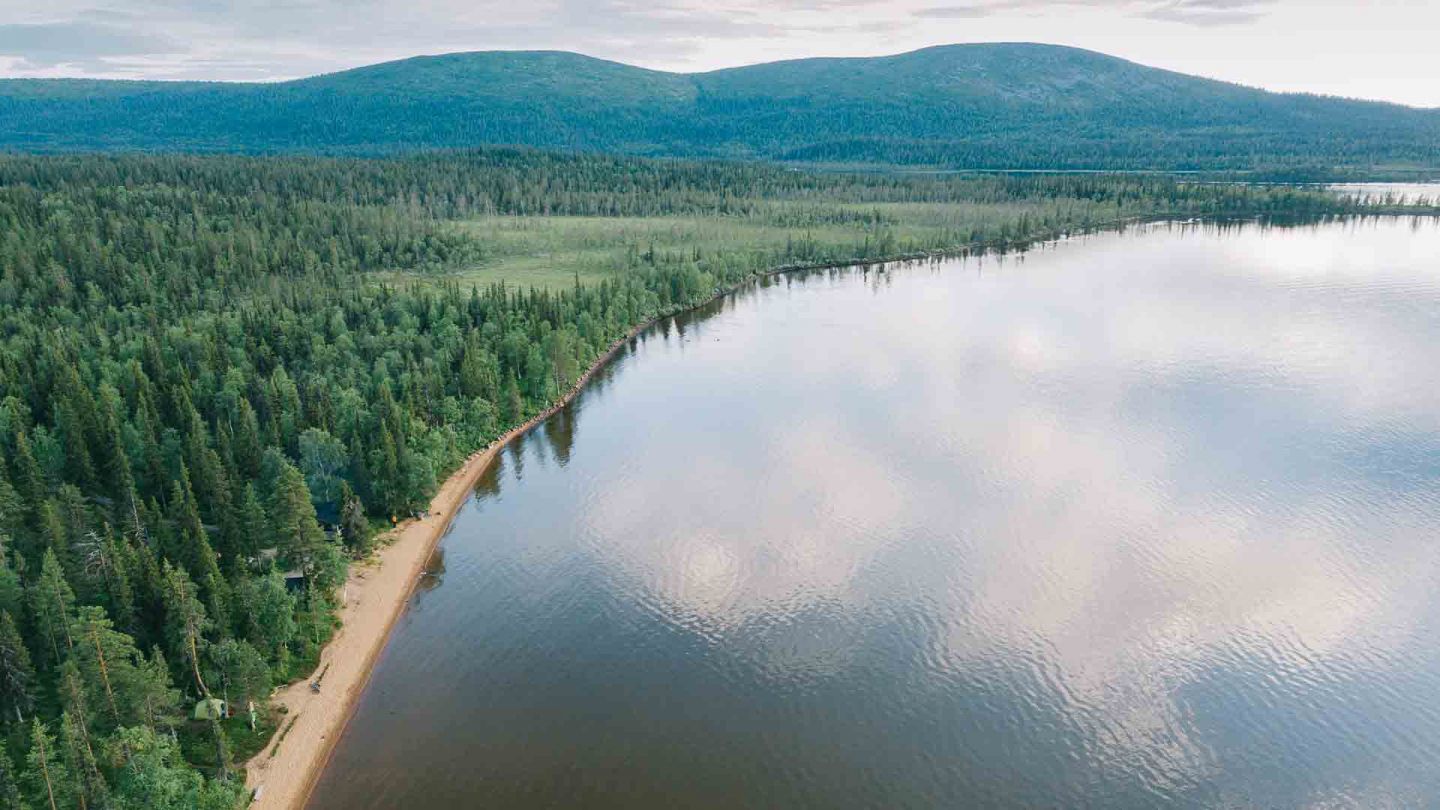 Red sand beach beside forest in Pallasjärvi, Finland