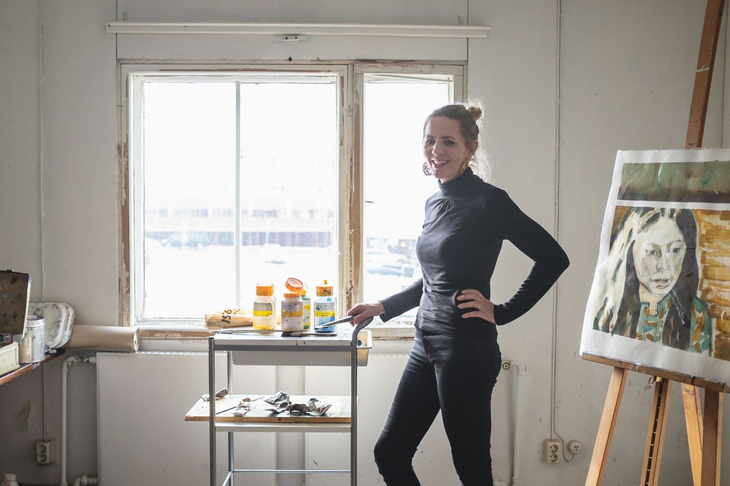 female artists standing in art studio surrounded by paintings