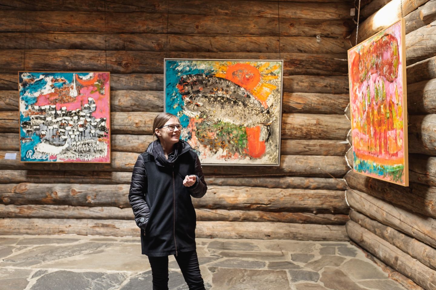 female museum director looking at Reidar Särestöniemi Museum gallery inside with paintings.