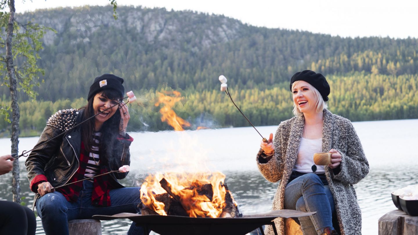 Carly Rae Jepsen and her crew enjoying marshmallows by a campfire in Finnish Lapland