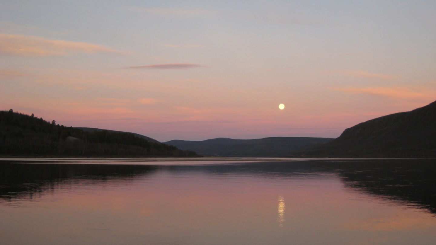 The Midnight Sun holds watch over a lake in Utsjoki, Finland in summer