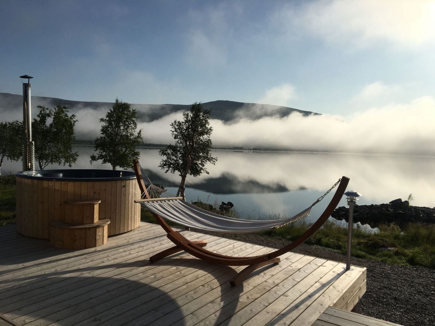 Hot tub and terrace overlooking a lake at Arctic Land Adventure in Lapland, Finland