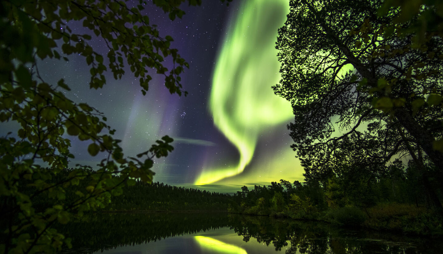Auroras reflecting in a lake in autumn in Finnish Lapland