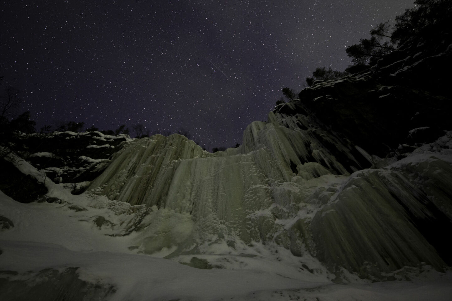 Dark skies and sparkling stars over the frozen waterfall at the Korouoma Canyon in Posio, a Finnish Lapland filming location