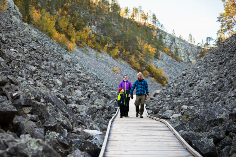 A family walks through a stony gorge in Pelkosenniemi, a Finnish Lapland filming location