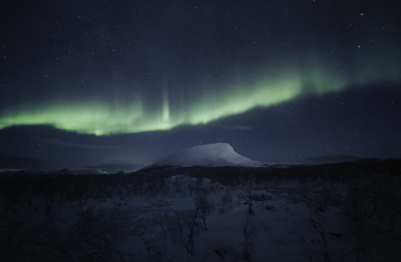 The Northern Lights over Mt. Saana, an Arctic fell in Kilpisjärvi, a Finnish Lapland filming location