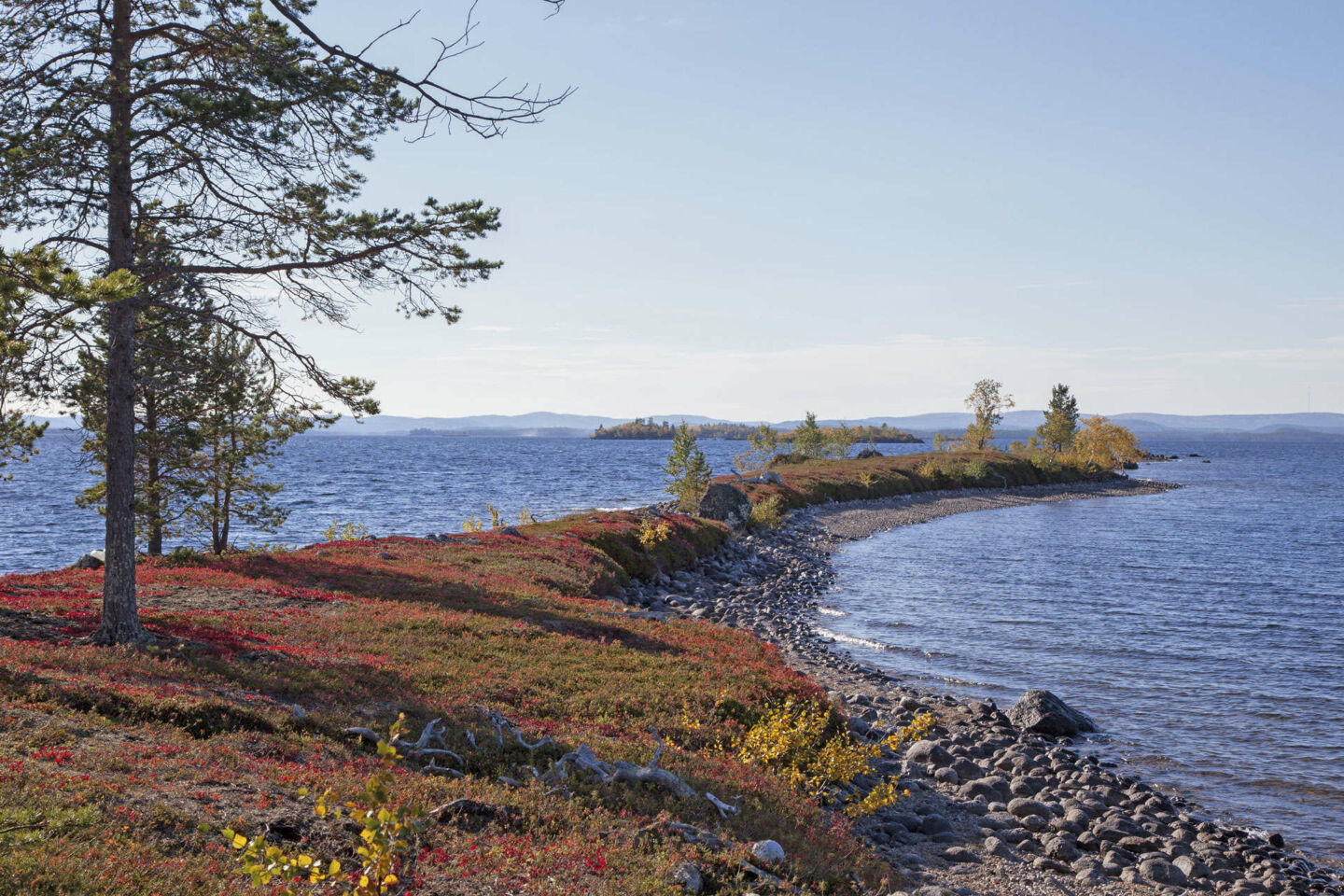 A sliver of beach extends into Lake Inari in summer, a filming location in Finnish Lapland