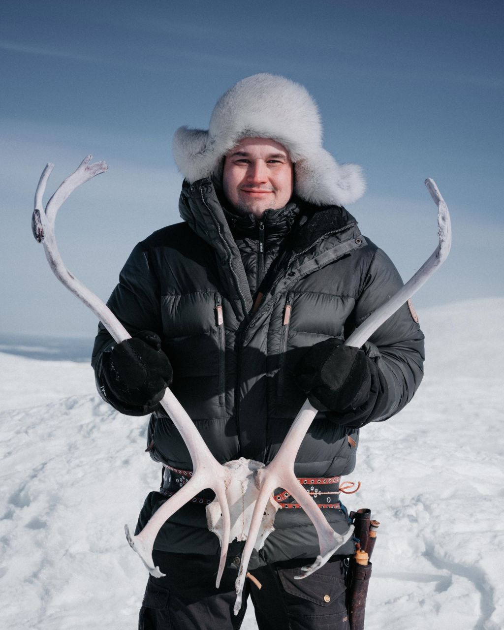 Ante Aikio holding reindeer's antlers in the winter