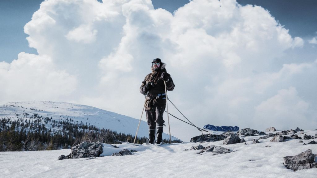 A man with winter gear is skiing on top of a fell