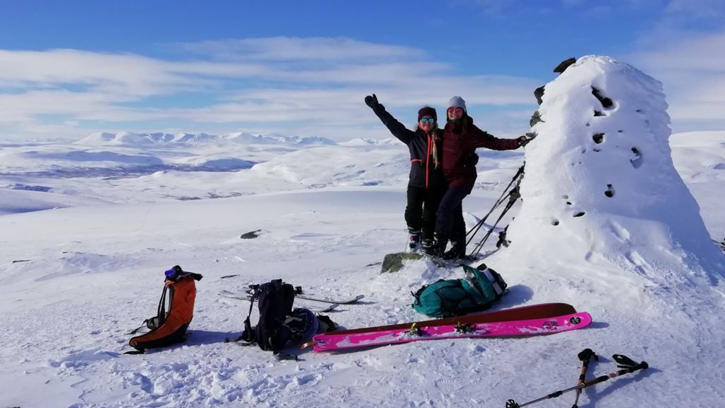 Two people with ski gears on top of a fell in Enontekiö in the middle of snowy winter.