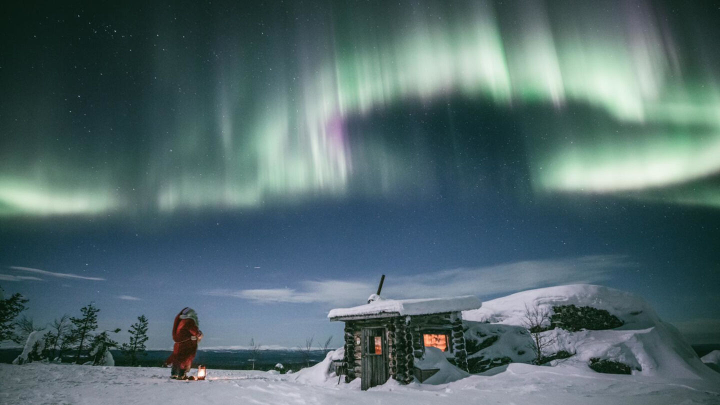 Santa Claus watches the Northern Lights over Mt. Korvatunturi in Savukoski, Finland