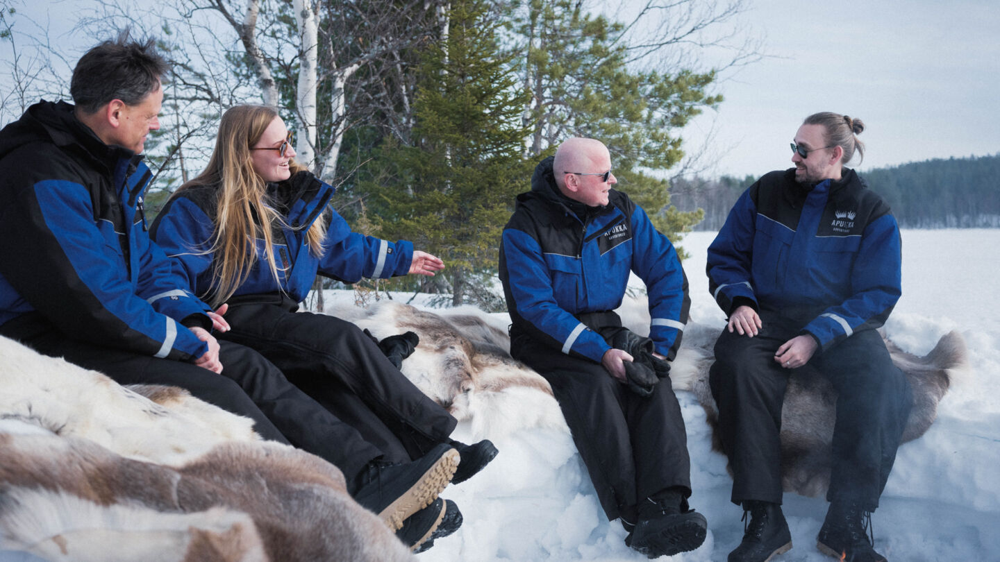 Four travellers talking by the fire in Rovaniemi Lapland