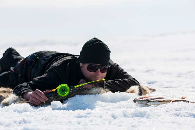 Ice fishing on the frozen winter lake in Inari, a film location in Finnish Lapland