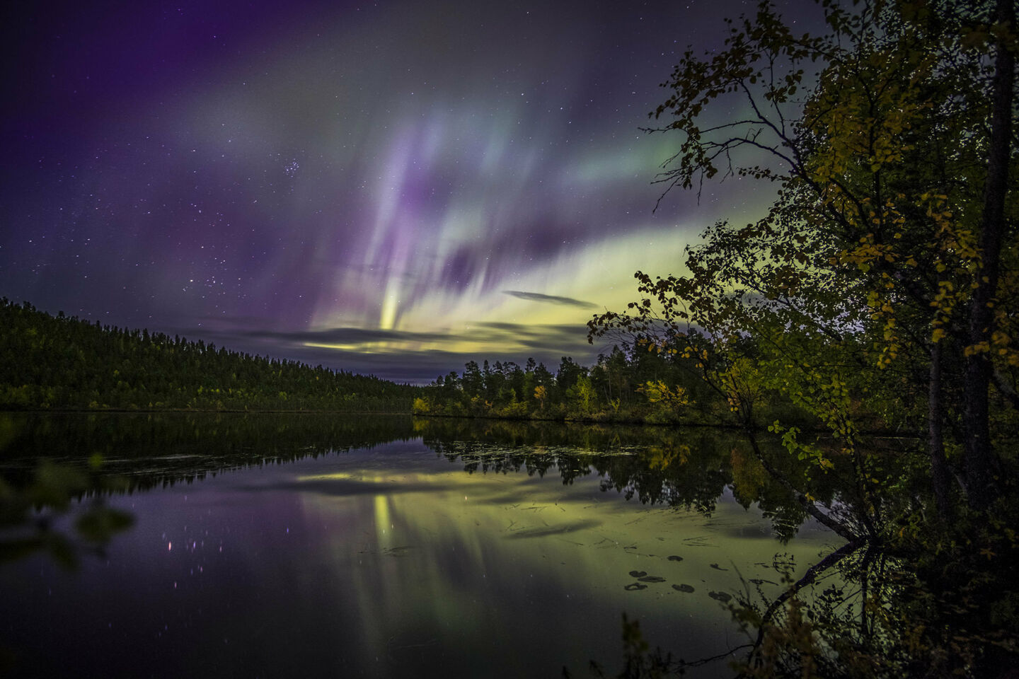 Northern Lights reflected in a lake in Inari, Finland