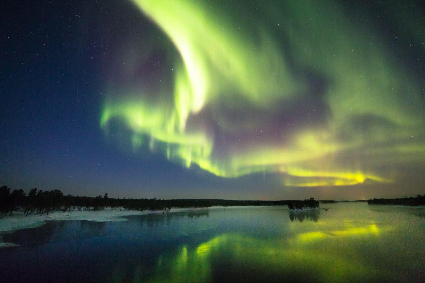 Northern Lights over a lake, a Finnish Lapland filming location feature