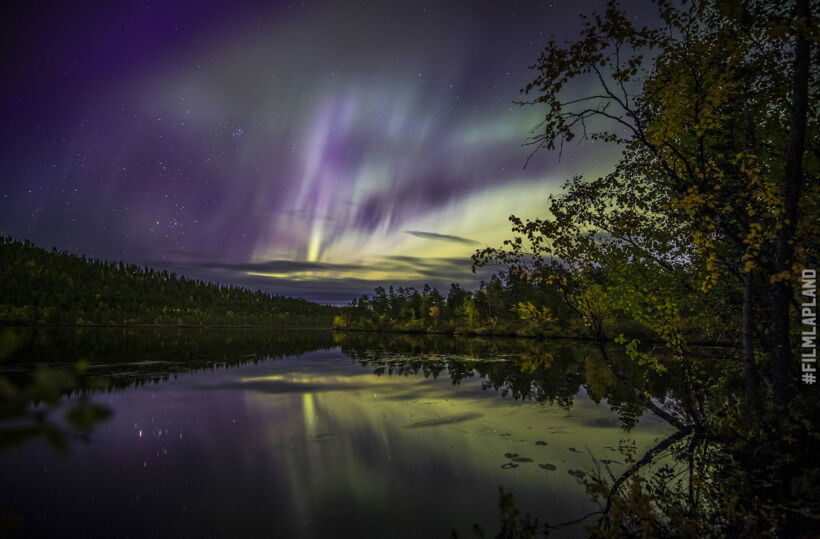 Northern Lights over a lake in Inari, a Finnish Lapland filming location feature