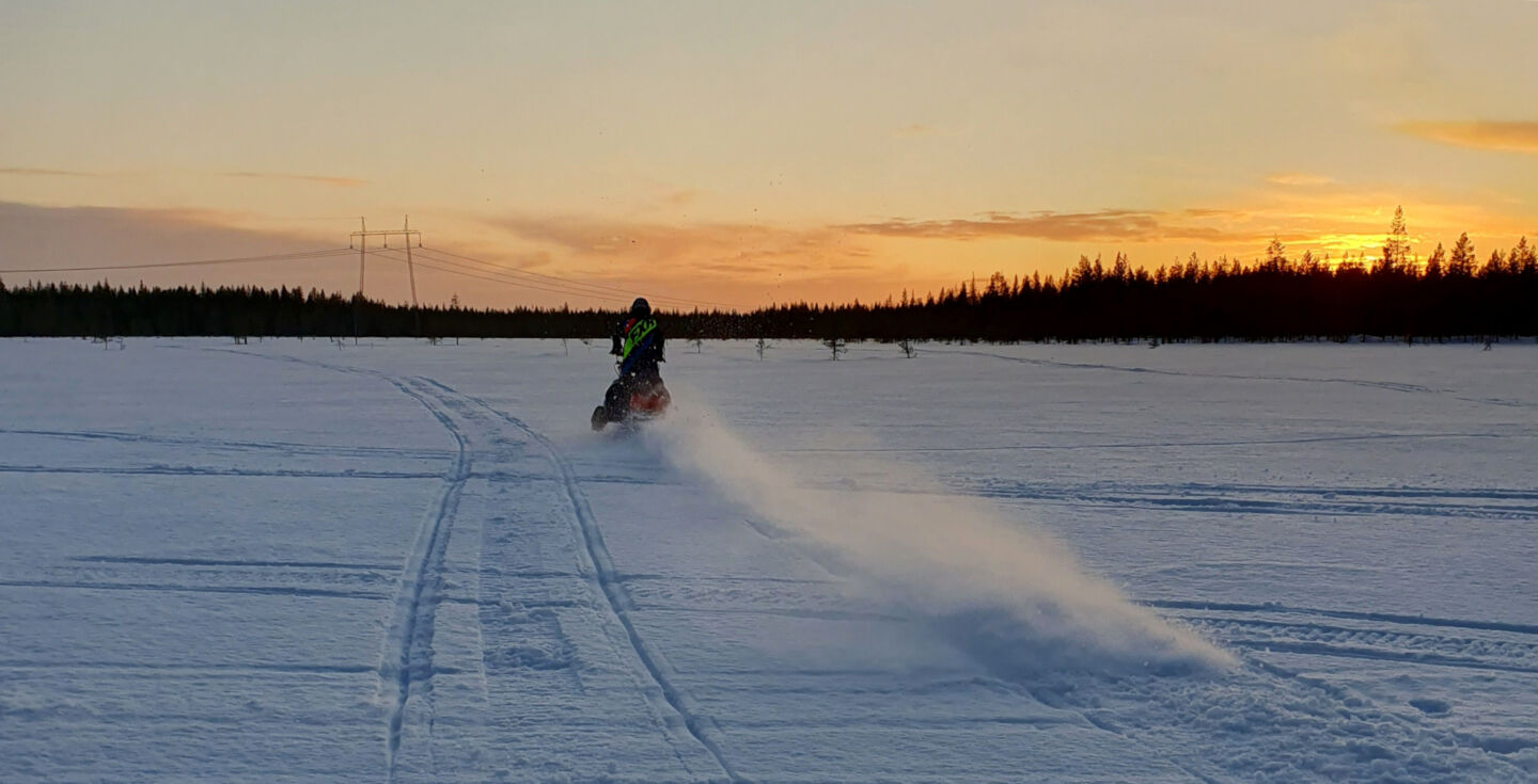 Snowmobiling across a frozen lake in Ranua, a filming location in Finnish Lapland